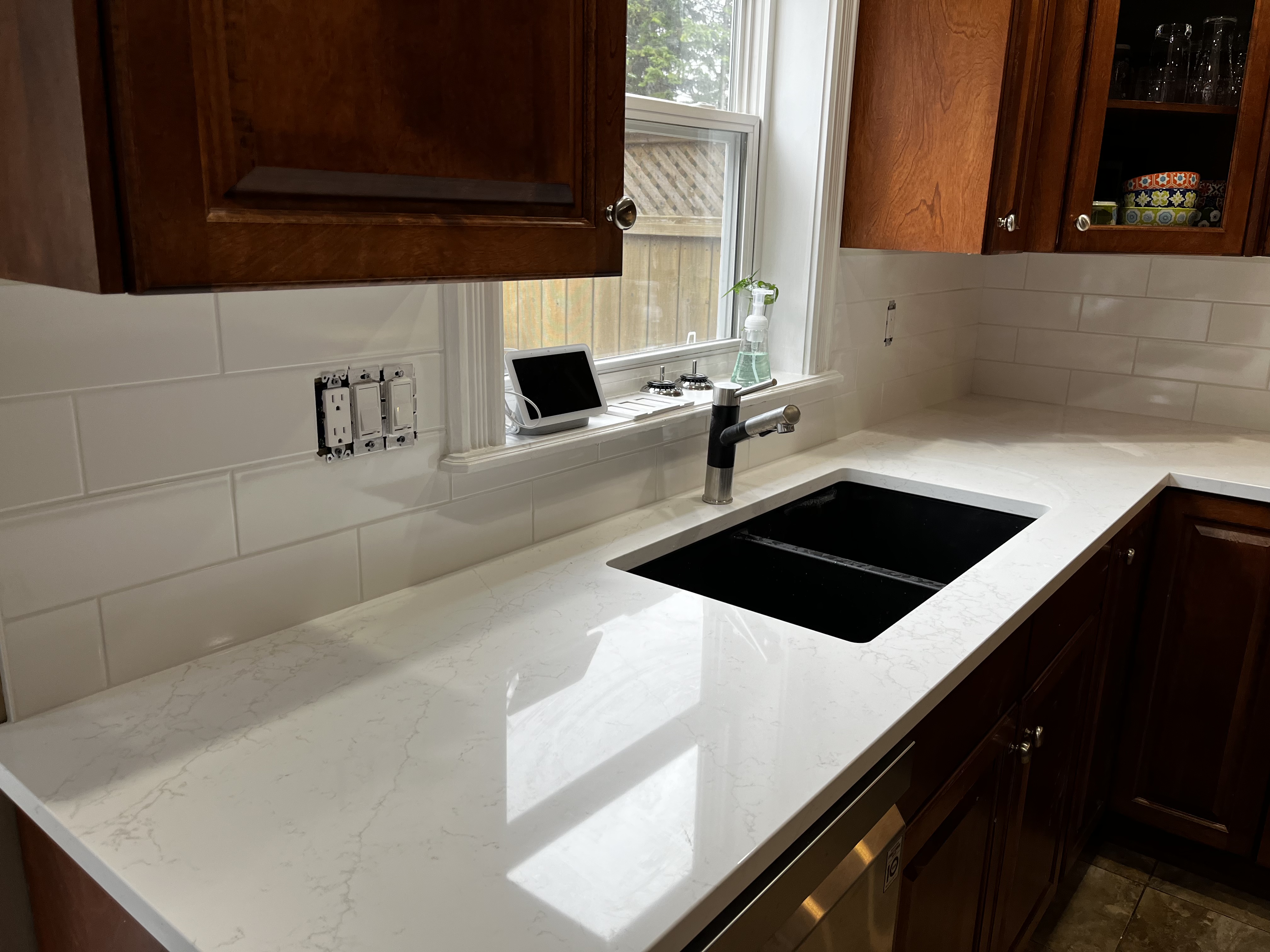 New Quartz counters with an undermount granite sink and tile backsplash