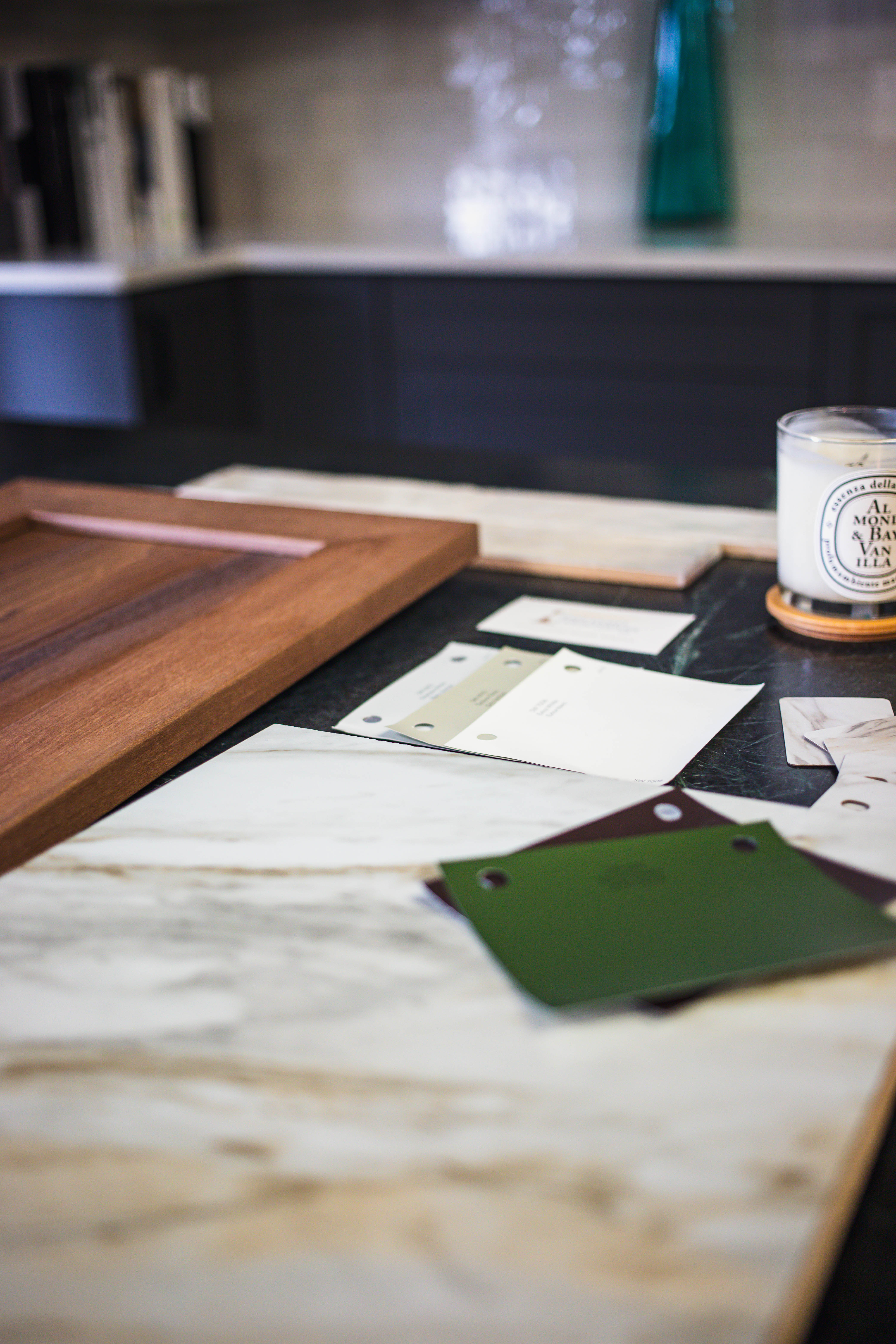A flat lay photography image of the Drama Marble countertop, along with paint swatches, cabinet door, and tile swatches that are mentioned in the blog article.