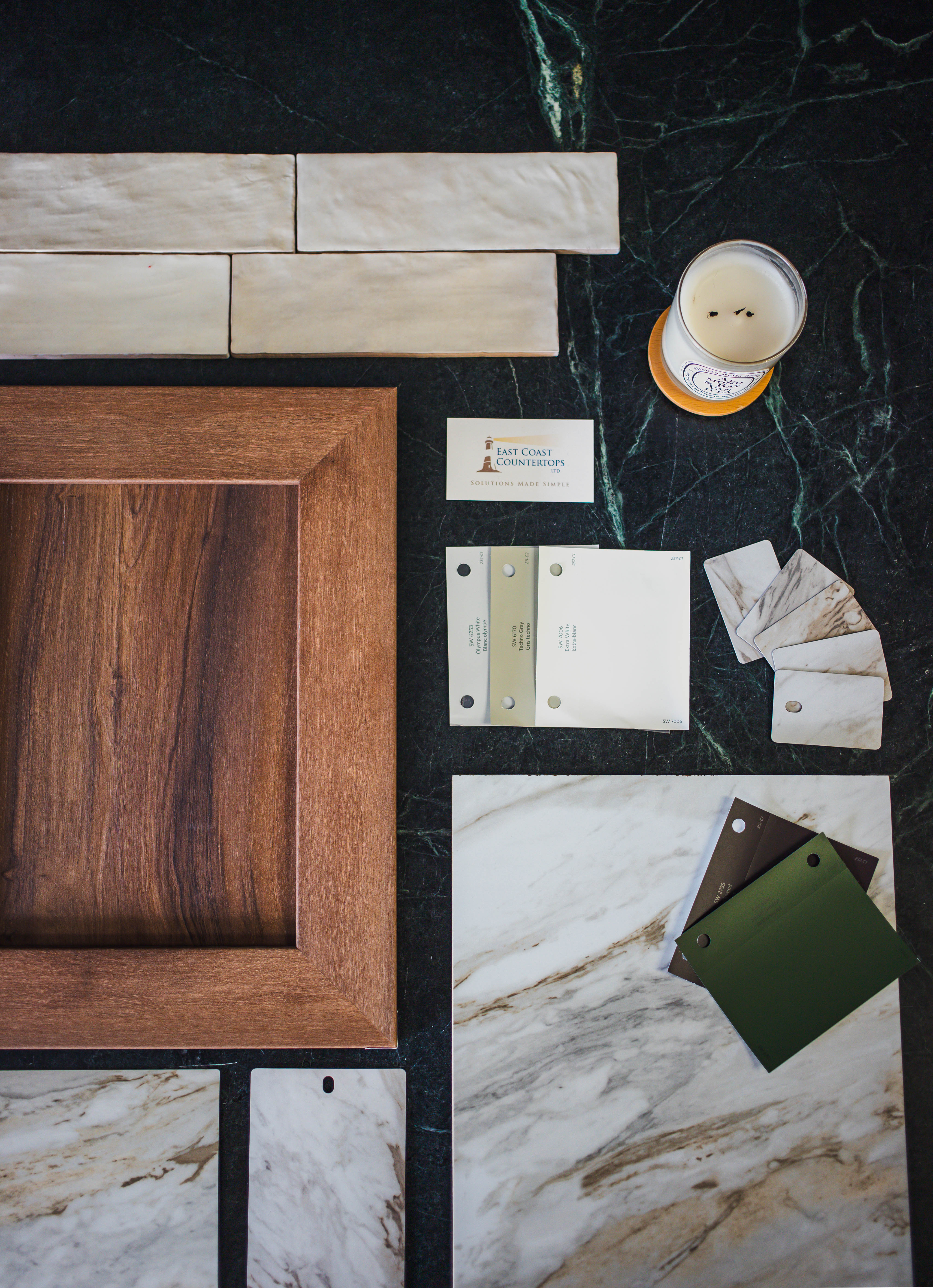 A flat lay photography image of the Drama Marble countertop, along with paint swatches, cabinet door, and tile swatches that are mentioned in the blog article.