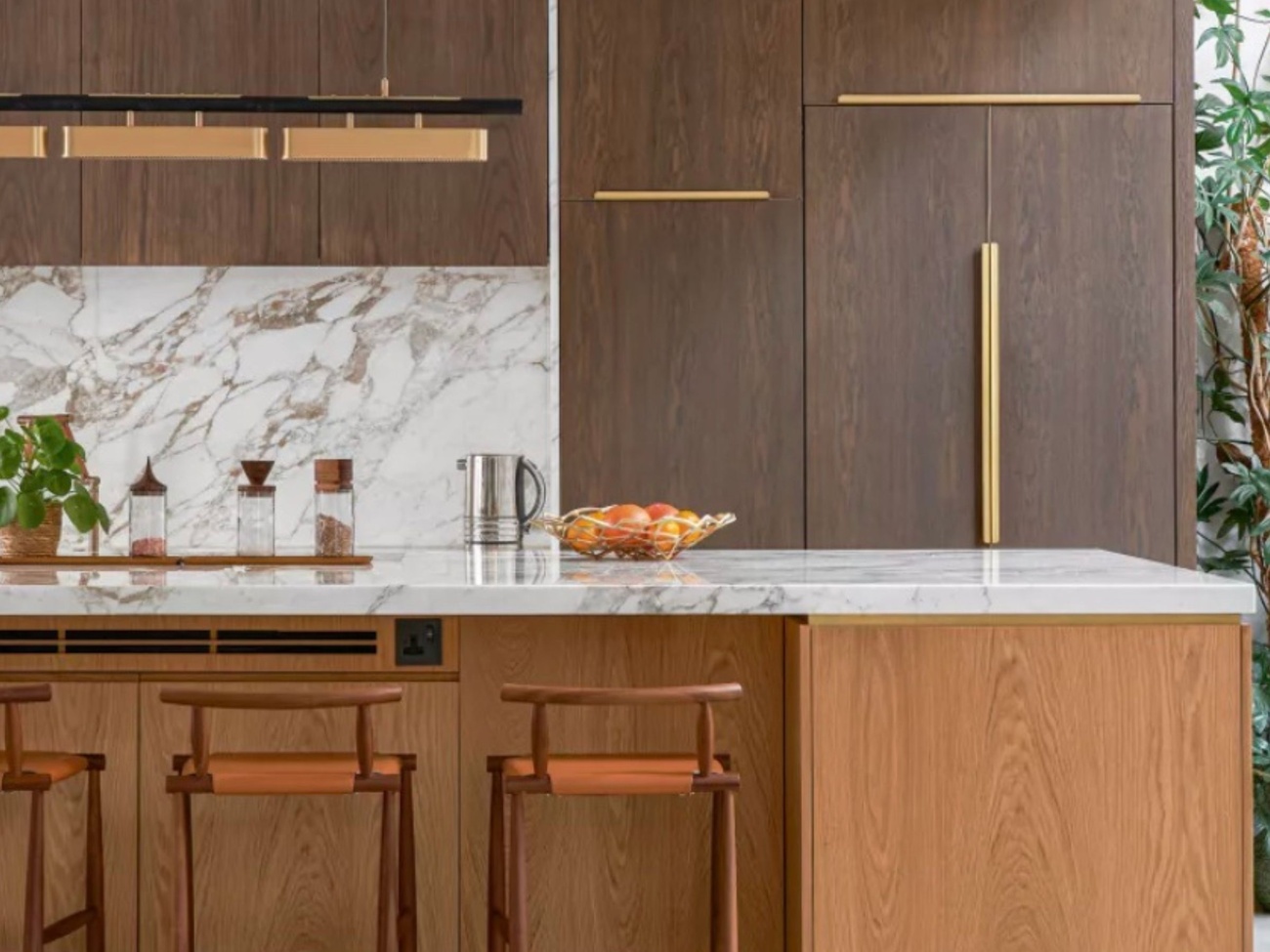 Brown and orange themed kitchen with white quartz countertop and brown veining 