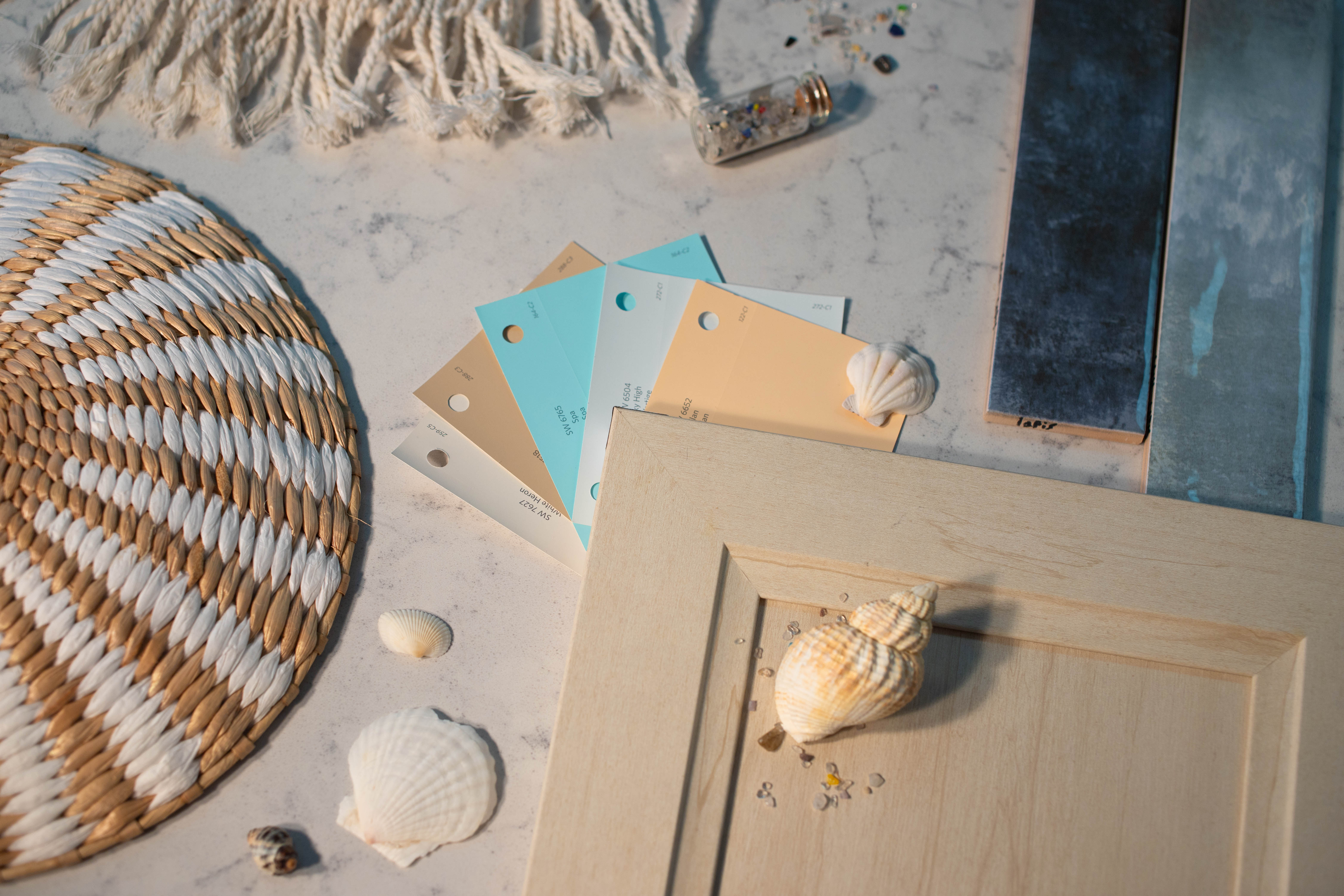 Flat lay photography of Neo Cloud countertop with coastal items on top and paint swatches and tile 